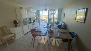 A compact living space with a dining area, kitchenette, and a balcony with a view. - Family friendly place for those looking for adventure, beach, and great food! (Ceiba)