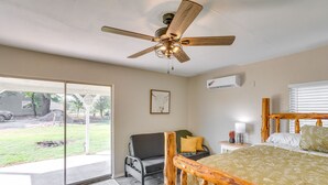 A bedroom with a bed, a ceiling fan, a window, and a view of the outdoors. - Oklahoma Home Near Lake w/ Patio, Grill & Chiminea (Fort Cobb)