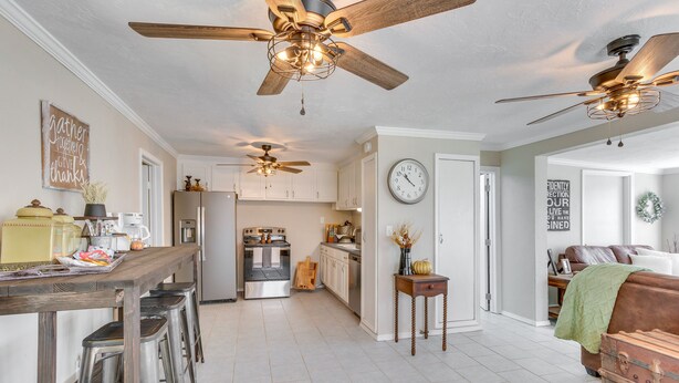 A spacious kitchen with modern appliances, a dining area with bar stools, and a cozy living room with a fireplace. - Oklahoma Home Near Lake w/ Patio, Grill & Chiminea (Fort Cobb)