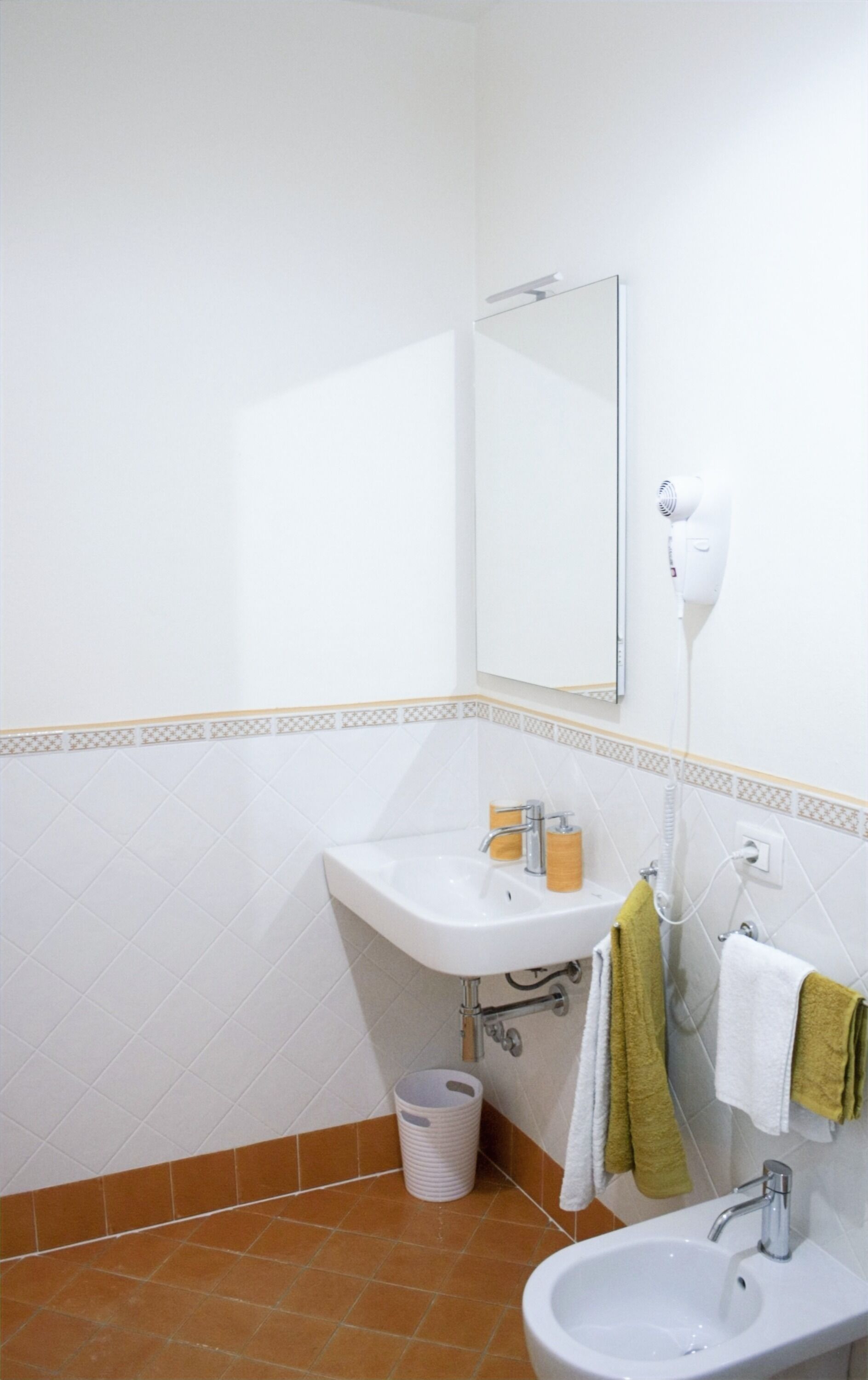 Ein Badezimmer mit Waschbecken, Spiegel und Handtuchhalter.