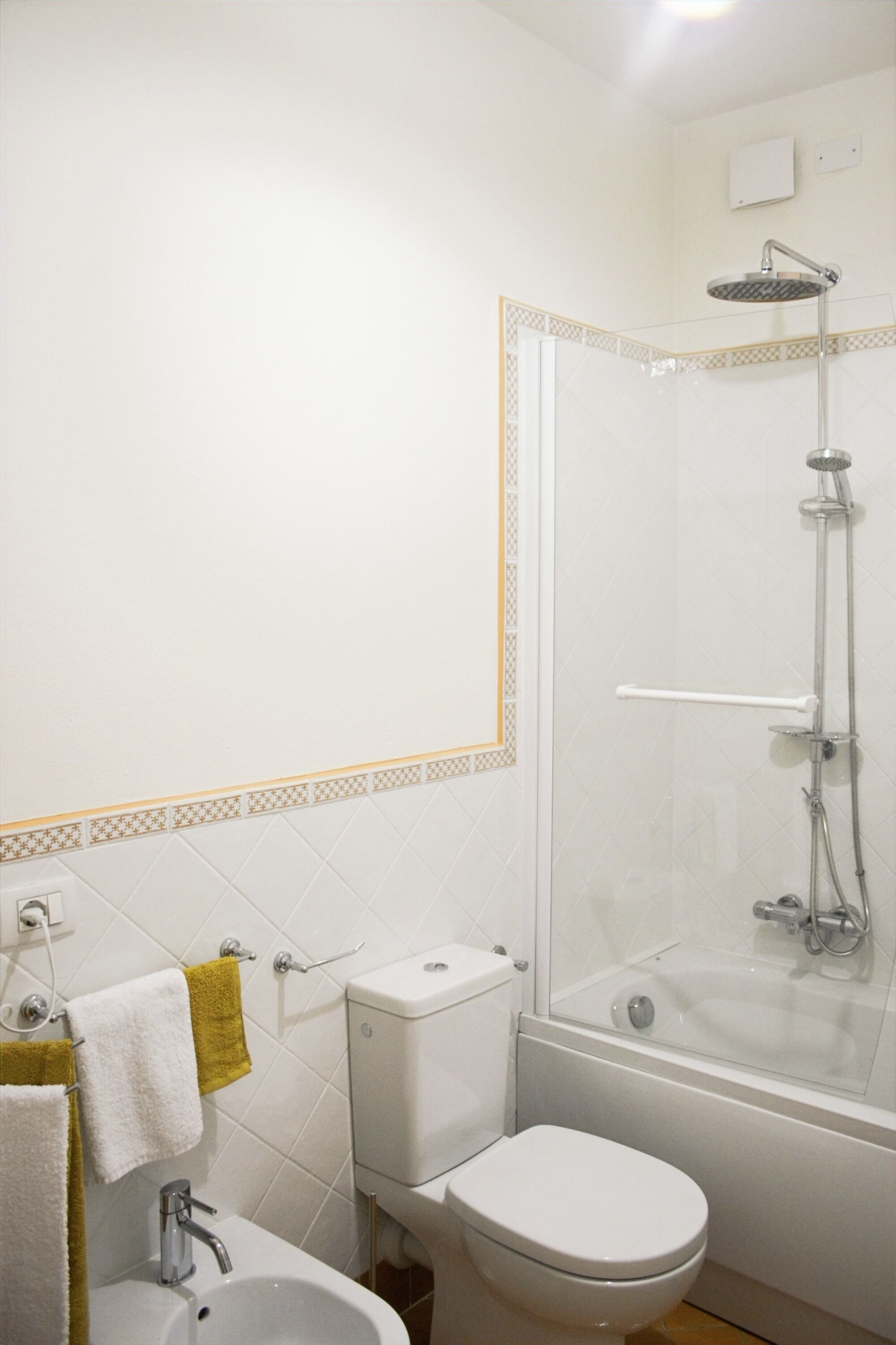 A bathroom with a toilet, sink, and shower.