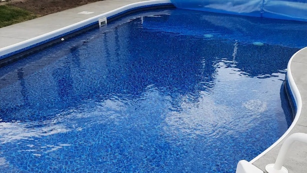 Een zwembad met een blauw mozaïek tegelontwerp.