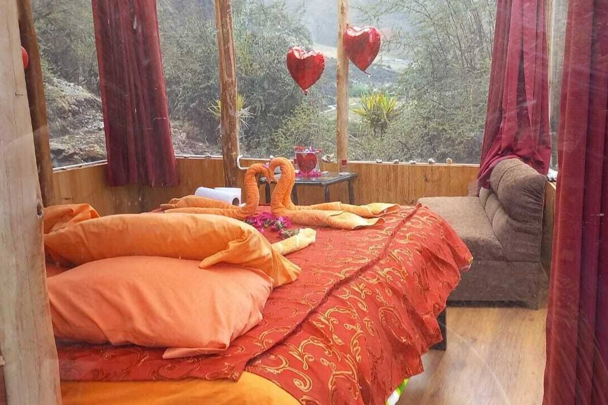 Una habitación acogedora con una cama, una mesita y vistas al exterior.