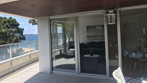 A balcony with a sliding glass door, a sofa, a small table, and a chair. - Arcachon Pereire Appartement Pieds Dans Leau (Arcachon)
