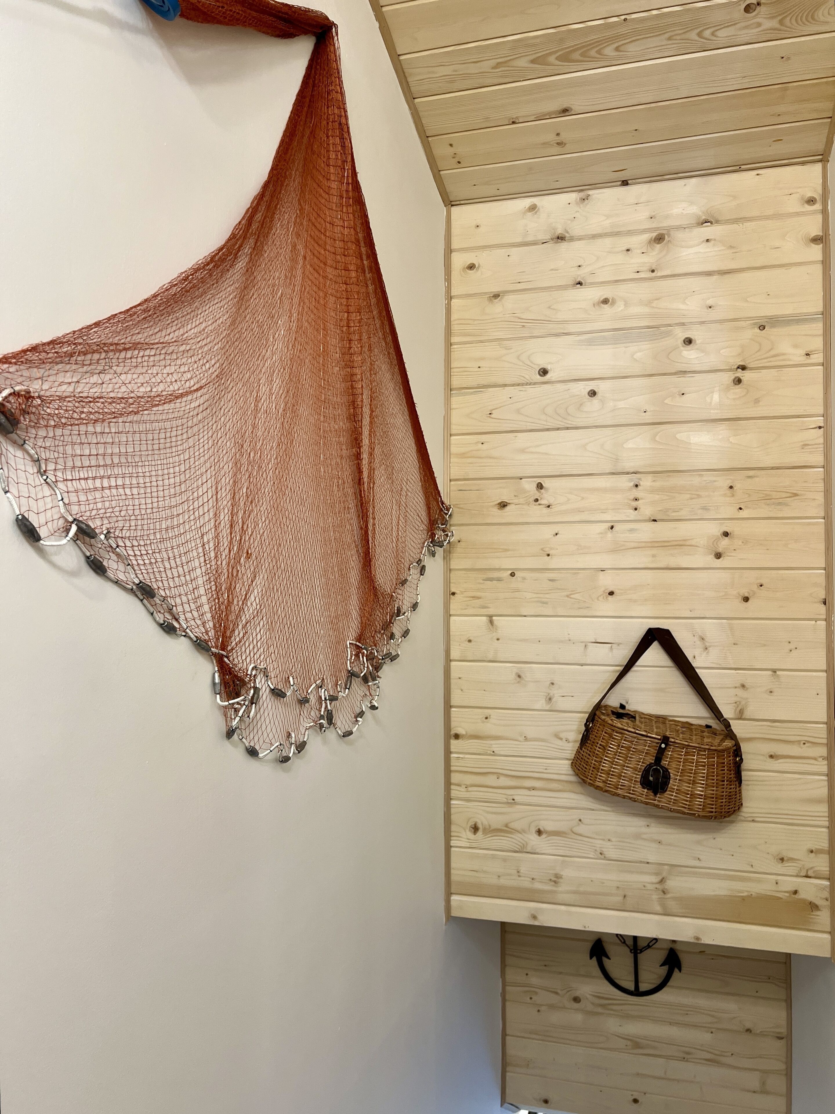 A room with a wooden ceiling and a wall-mounted basket.