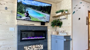 A modern living room with a fireplace, television, and decorative items.