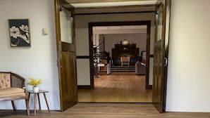 A wooden staircase leading to a living area with a sofa and a small table with a plant.