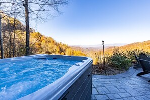A hot tub with a view of a mountainous landscape.