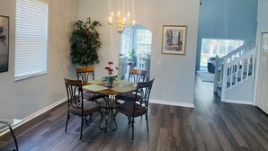 A dining area with a chandelier, a potted plant, and a framed picture on the wall. - Oakchase villa with pool and gameroom sleeps 8 guests easy!  (Davenport)