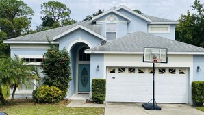 A residential house with a garage, a basketball hoop, and a mailbox. - Oakchase villa with pool and gameroom sleeps 8 guests easy!  (Davenport)