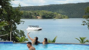 A swimming pool with a view of a lake and a boat in the distance. - Aldeia do Lago 306H (Caldas Novas)