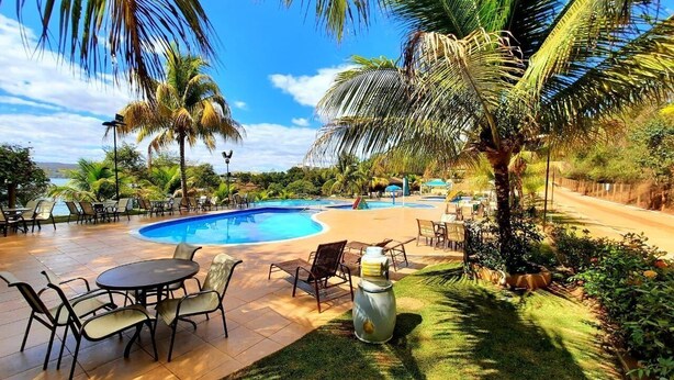 Un área junto a la piscina con una piscina circular, sillones de descanso y una mesa.