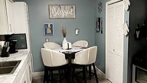 Une cuisine équipée d’une table à manger, de chaises, d’un réfrigérateur et d’une cuisinière.
