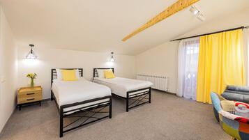 Une chambre avec deux lits, un plafond en bois, un radiateur et une chaise.