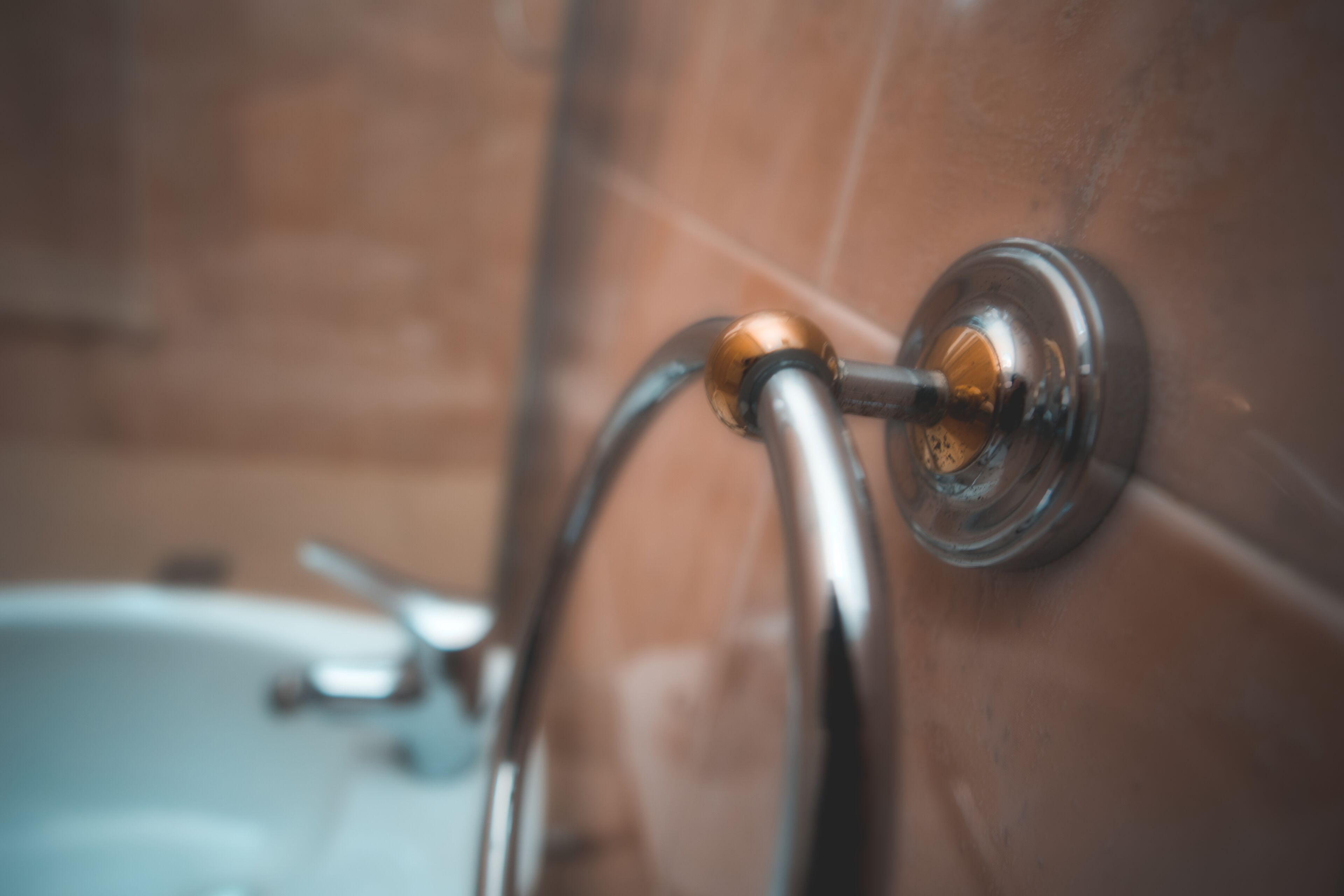 Eine Nahaufnahme eines Badezimmeraccessoires, vermutlich einer Dusche oder eines Wasserhahns, mit metallischer Oberfläche und runder Basis.