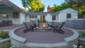 A patio with a fire pit and outdoor seating. - Luxury Riverfront Escape- Hot tub & Fire Pit (Roseburg)