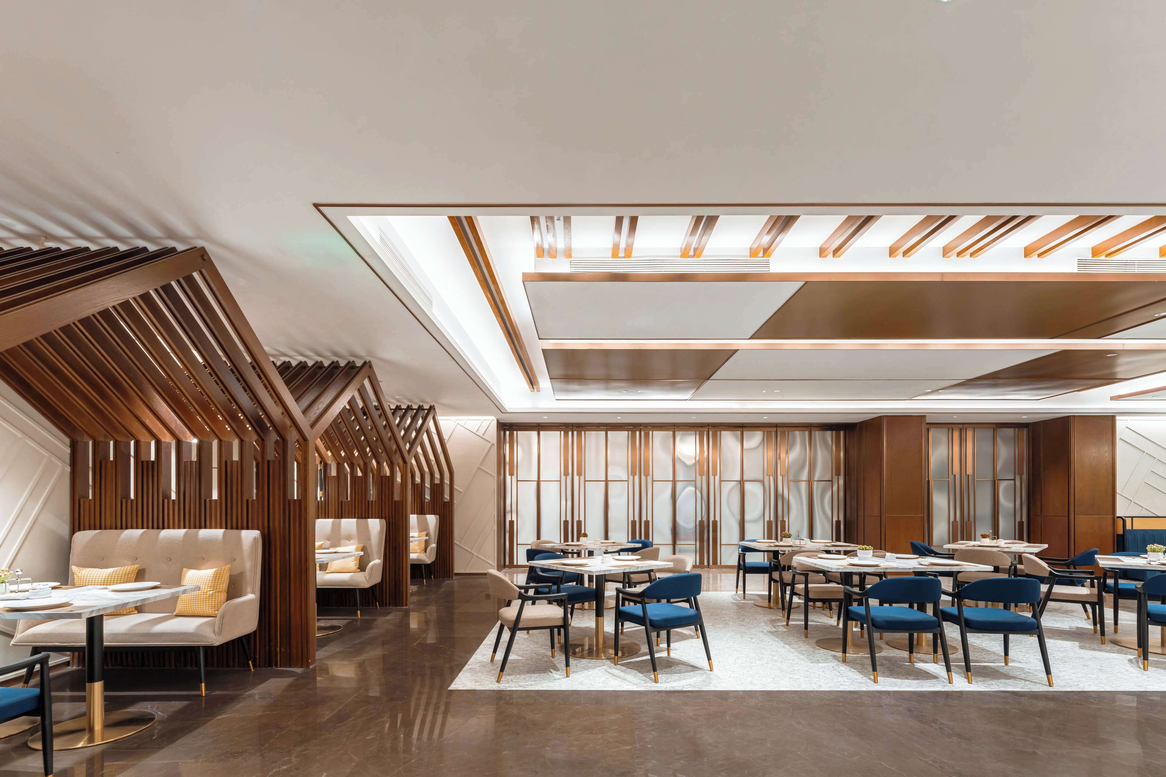 A modern hotel lobby with a seating area, a bar, and a large window.