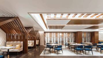 A modern hotel lobby with a seating area, a bar, and a large window.