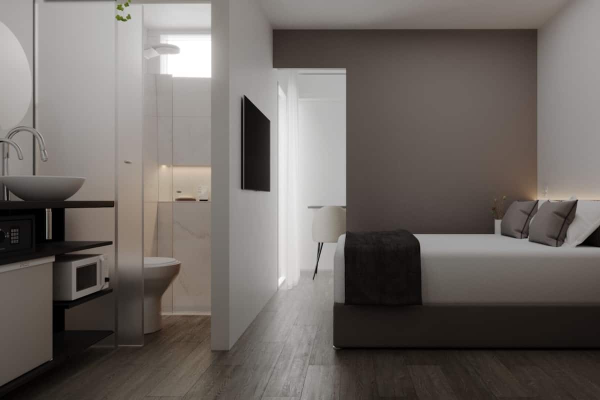 A modern bedroom with a bed, bedside table, and a TV.