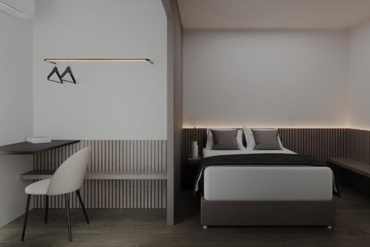 A modern bedroom with a bed, bedside tables, a chair, and a desk.