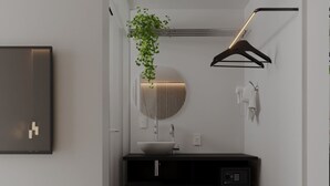 A modern bathroom with a white sink, dark countertop, and a hanging plant. - Itaim Internacional Stay (São Paulo)