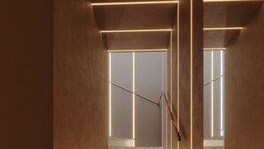 A modern staircase with illuminated handrails and a metal grate at the bottom. - Itaim Internacional Stay (São Paulo)