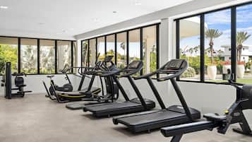 A modern gym with treadmills, ellipticals, and weight machines.