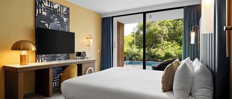 Una habitación de hotel moderna con una cama grande, un escritorio con televisor de pantalla plana, cafetera y vista a una piscina.