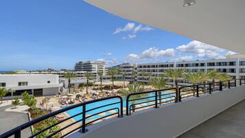 Un resort con piscina, palmeras y vistas al mar.