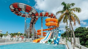 A water park with multiple slides and water features, surrounded by palm trees and a pool. - The Rif at Mangrove Beach Corendon Curacao All-Inclusive, Curio by Hilton (Willemstad)