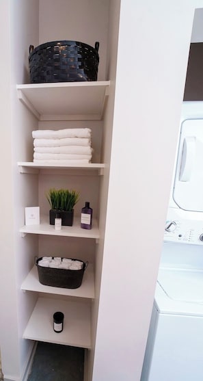 A laundry area with shelves holding towels, a basket, and a potted plant. - ⭐️New Listing⭐️ Luxurious Condo Downtown Memphis  (Memphis)