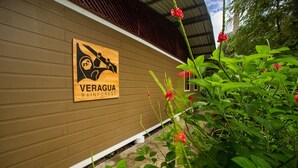 A wooden building with a sign reading "VERAGUA RAINFOREST". - Veragua Rainforest Lodge (Río Blanco)