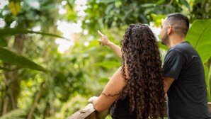 A couple standing outdoors, surrounded by lush greenery. - Veragua Rainforest Lodge (Río Blanco)