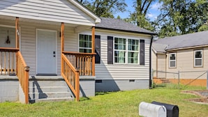 A single-story house with a front porch, a mailbox, and a small front yard.