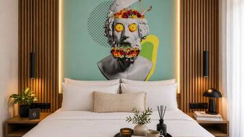 A modern hotel room with a bed, a nightstand, a lamp, a tray with a mug, a vase, and a book.