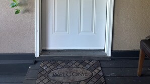 A white door with a number '2' above it, a welcome sign, and a code sign pointing to the door. - Modern Private Share Bedroom Bus stop to NYC (Englewood)