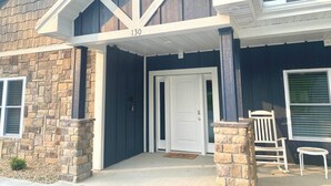 Une maison avec une façade en pierre, une porte blanche et une boîte aux lettres.