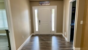 A hallway with a wooden floor, white walls, and a double door with a frosted glass window. - YES! 🎸FamilyPlace 🏊‍♀️POOL/WaterFall💦HOTTUB 🔥FIREPIT🎱POOLTABLE⚡EV🎡FUN❤️LUV (Branson)