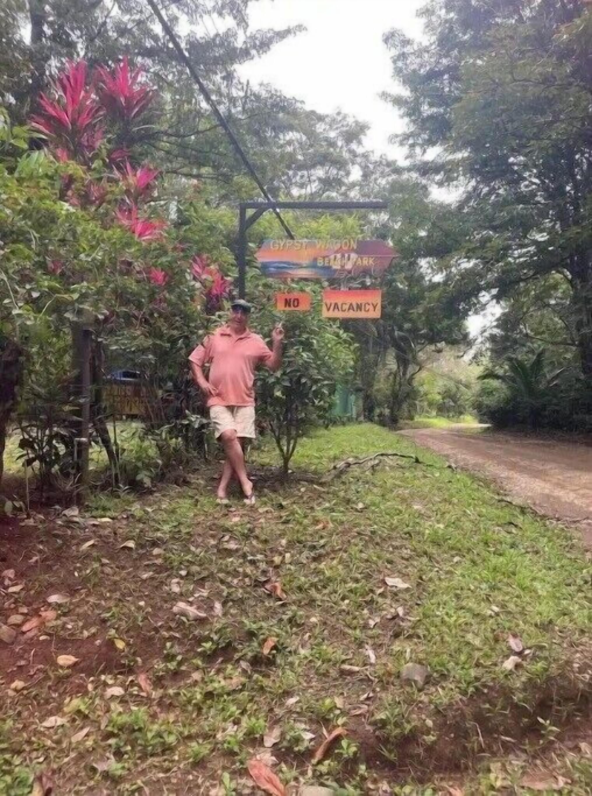 Un hombre de pie cerca de un cartel que dice 'GYRST VION BELT PARK' y 'VACANCIA'.