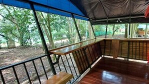 Eine Holzterrasse mit einer Bank, einem Tisch und einem roten Schrank.