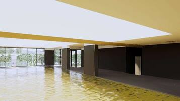 A spacious indoor area with a reflective floor, large windows, and a high ceiling.