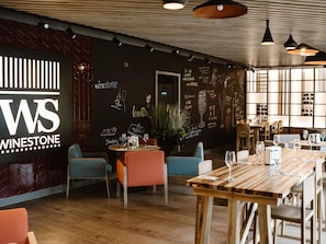 Un interior de restaurante con un menú en la pizarra, mesas y sillas de madera.