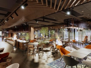 A modern cafe with wooden accents, tables, and chairs, and a bar area. - Mercure Sibiu Arsenal (Sibiu)
