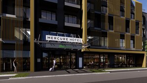 Un hotel modern amb un senyal per a 'Mercure Hotel' i restaurant 'ibis Styles'.