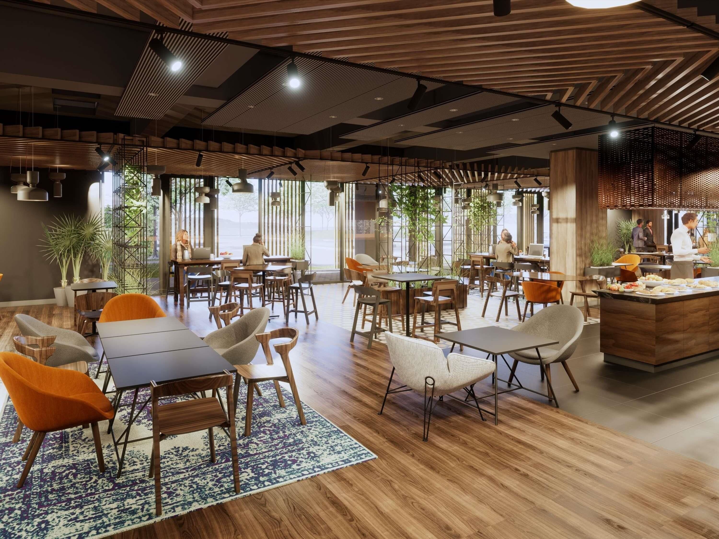 Un restaurante moderno con suelo de madera, varias zonas de comedor y grandes ventanales que permiten la entrada de luz natural.