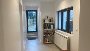 A hallway with a bookshelf, a radiator, and a window. - Large refurbished house in central village location (Dompierre-sur-Mer)