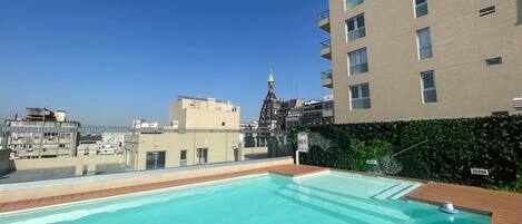 A rooftop pool with a clear view of the city skyline, including a church spire.