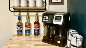 A kitchen with a coffee machine, three Torani syrup bottles, and a coffee mug rack. - Jewel Brook Cottage- 4BR house on a tranquil flowing brook!  (Ludlow)