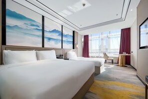 A hotel room with two beds, a desk, and a large window with curtains.