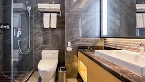 A modern bathroom with a glass-enclosed shower, a toilet, a sink, and a vanity with a mirror. - Grand Madison Jingzhong Yuci Haitangwan (Jinzhong)